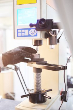 Laboratuvarda zor test edilir, metalin gücü ölçülür..