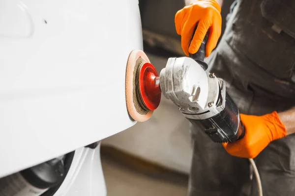 Trabajador limpiando coche blanco con pulido y encerado, primer plano. taller de reparación de automóviles. — Foto de Stock