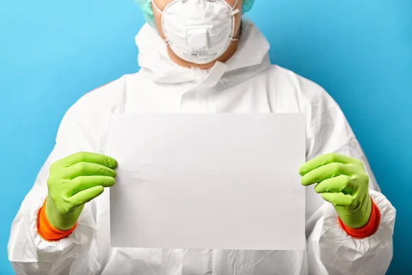 保護滅菌衣類や呼吸マスクの医療従事者の閉鎖は、テキストのための白いシートと青の背景に立っています. — ストック写真