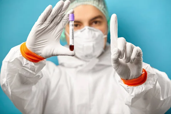 Medical analysis for coronavirus. Doctor holds test tube with the result of the analysis for covid-19.