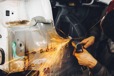 Kaynak temizliği. Kaynak dikişlerinin aşındırıcı bir tekerlek ile pnömatik taşlama makinesinin işlenmesi. Araç gövdesinin onarımı.