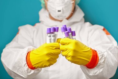 Koronavirüsün analizi için tıbbi test tüplerini kapatın. Korunaklı kıyafetler giyin..