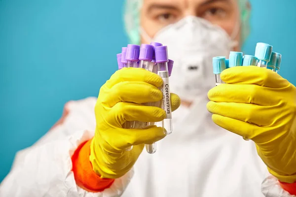 コロナウイルスの解析のための医療チューブcovid-19.保護服やマスクの医師は2019-nCoVのテストを開催しています. — ストック写真