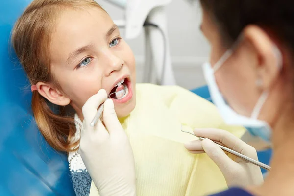 Menina em uma visita ao dentista no escritório de odontologia pediátrica . — Fotografia de Stock