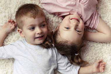 küçük erkek ve kız yatakta dinleniyor