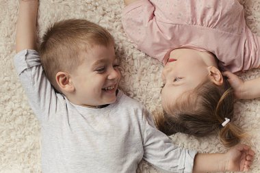 küçük erkek ve kız yatakta dinleniyor