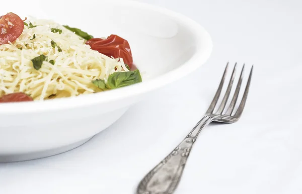 Tabak spagetti domates, fesleğen ve rendelenmiş peynir ile