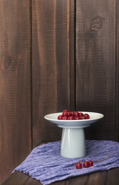 Ahşap arka plan ile kırmızı kuş üzümü.