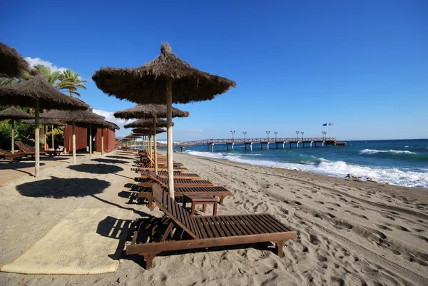 Daitona sahilinde boş şezlonglar ve şemsiyeler, Marbella, İspanya.