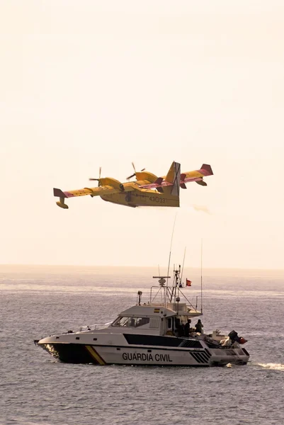 Bombardier / canadair cl415 Feuerbomber (Nummer 2069-4333) fliegt über ein ziviles Boot der Guardia Civil, nachdem er Meerwasser gesammelt hat, Calahonda — Stockfoto