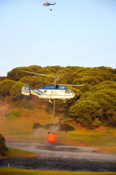 Kamov ka-32a11bc Hubschrauber (Registrierung ec-jsq), der Löschwasser aus einem Golfplatzsee sammelt, cabopino golf, spanien. — Stockfoto