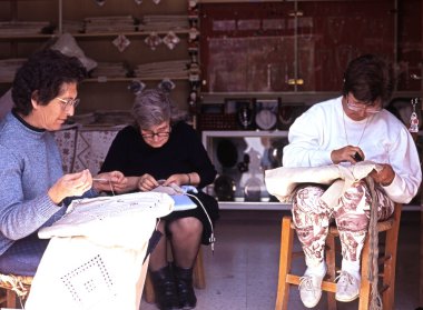 Three Cypriot women lace making in a shop doorway, Kato Lefkara, Cyprus. clipart