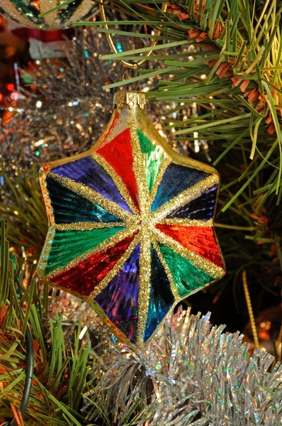 Ornamento de estrela de vidro colorido na árvore de Natal . — Fotografia de Stock
