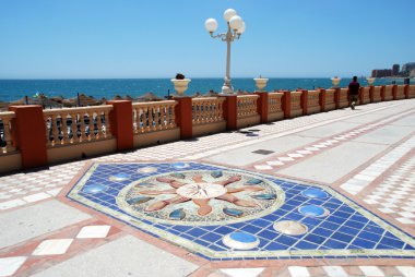 Marine life pictures adorning the promenade pavement with the sea to the rear, Benalmadena, Spain. clipart