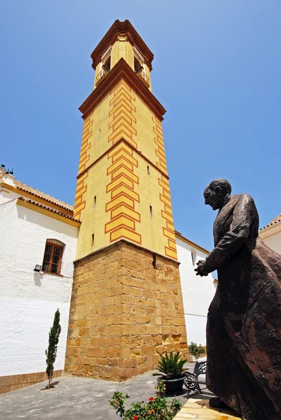 Vista de una iglesia con un campanario alto con una estatua en primer plano, Estepona, España . — Foto de Stock