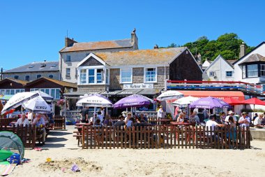 Turistler arka Harbour Inn bara ile bir plaj kafede dinlendirici Lyme Regis.