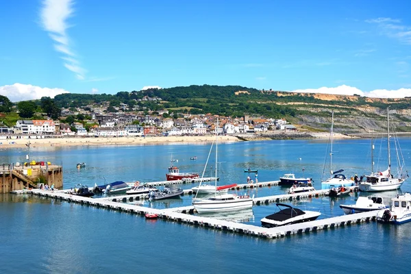 Jachty zacumowane w ponton z widokiem w kierunku plaży i miasta, Lyme Regis. — Zdjęcie stockowe