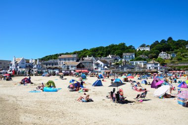Tatilciler rahatlatıcı arkaya, şehir binaları ile sahilde Lyme Regis.