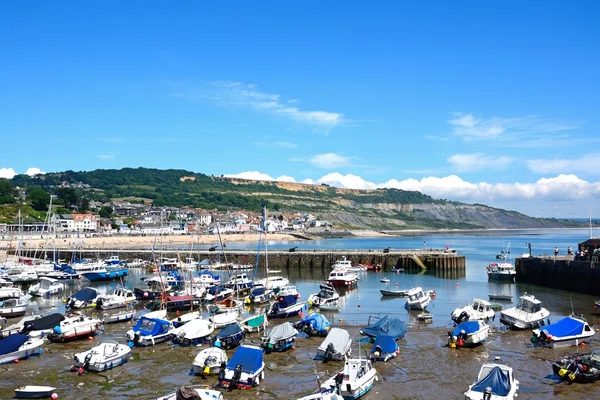 Boote und Yachten im Hafen mit Blick auf Strand und Stadt, lyme regis. — Stockfoto