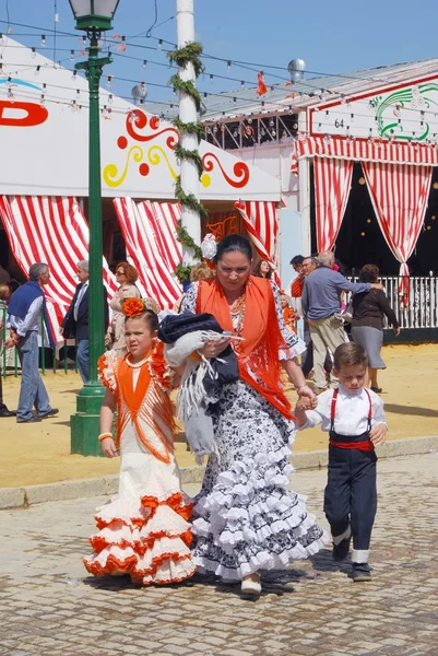 Madre española con sus hijos en traje tradicional paseando por la calle con Casitas en la parte trasera de la Feria de Sevilla, Sevilla . — Foto de Stock