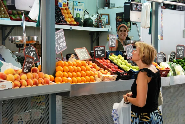 Customer being served at a fruit and veg stall in the indoor market (Mercado de Atarazanas), Malaga. — Stock Photo, Image