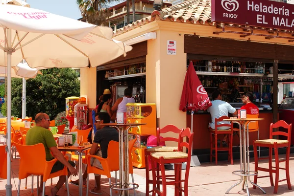 Personas que se relajan en una cafetería a lo largo del paseo marítimo, Estepona, España . — Foto de Stock