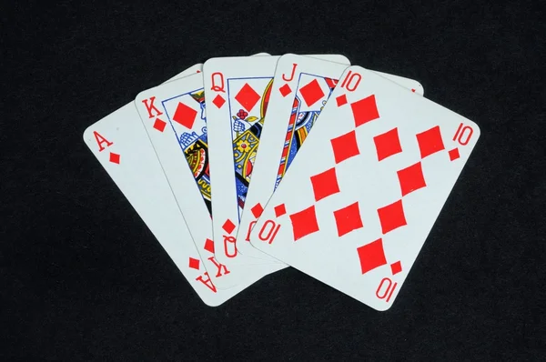 Royal flush poker hand in the diamond suit against a black background.
