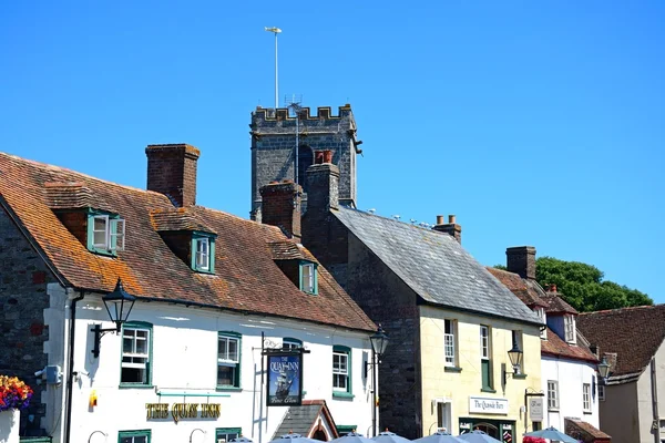 O pub Quay Inn e lojas com a torre da igreja Lady St Mary nas traseiras, Wareham . — Fotografia de Stock