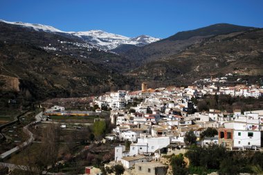 View of white village with the Sierra Nevada mountains to the rear, Cadiar, Spain. clipart