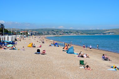 Plaj ve kıyı şeridi yaz güneş, Weymouth zevk tatilciler ile göster.