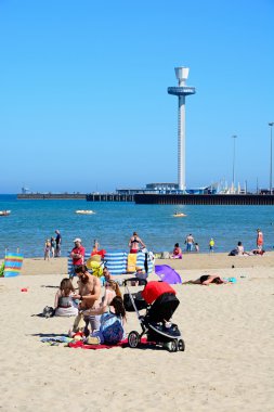 Tatilciler arka, Weymouth için Jurassic Skyline tower ile sahilde.