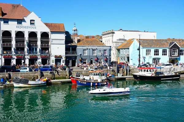 Fishing boats in the harbour with quayside buildings and pubs to the rear, Weymouth. — ストック写真