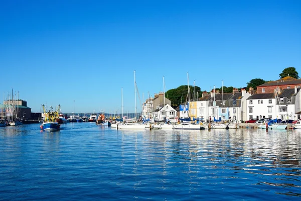 Yachts and fishing trawlers in the harbour with quayside buildings to the rear, Weymouth. — ストック写真