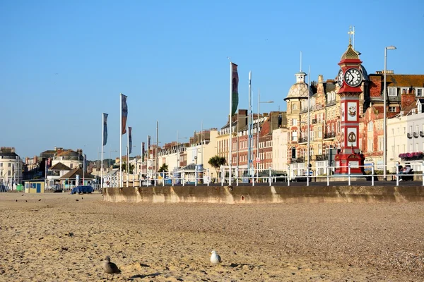 Vista a lo largo de la playa hacia los edificios del paseo marítimo por la mañana temprano, Weymouth . — Foto de Stock
