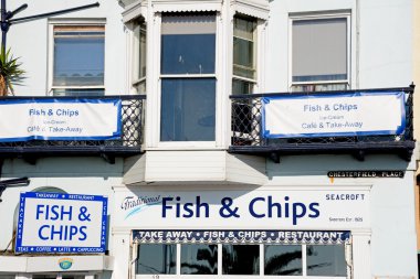 Geleneksel balık ve patates cipsi Dükkanı işaretleri boyunca Esplanade, Weymouth.