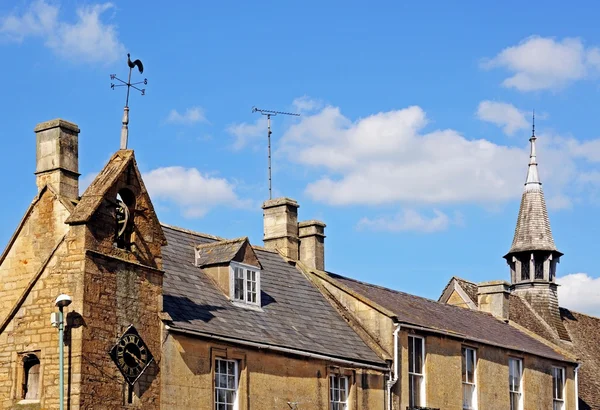 Détail architectural sur les bâtiments du centre-ville, y compris une tour de couvre-feu décorative à l'angle de High Street et Oxford Street, Moreton-in-Marsh, Royaume-Uni . — Photo