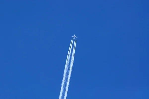 Emirates Airbus A380 con estelas contra un cielo azul . — Foto de Stock
