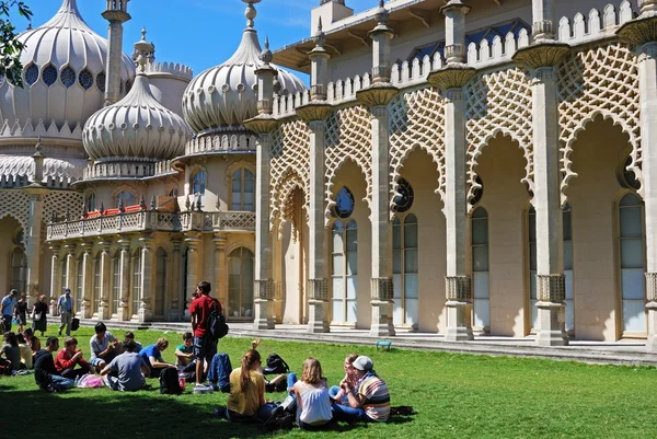 Grupo de personas sentadas en el césped en los terrenos del Royal Pavilion, Brighton, Reino Unido . — Foto de Stock