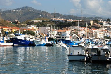 Balıkçı tekneleri ve yatlar görünümünü arka Caleta de Velez, İspanya için şehir binaları ile limanında demirlemiş.