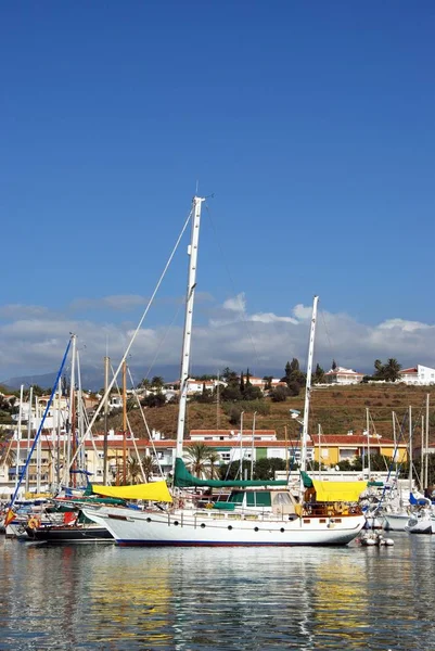 View of yachts moored in the harbour with town buildings to the rear, Caleta de Velez, Spain. — Stock Photo, Image