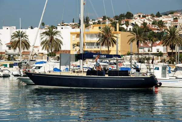 View of yachts moored in the harbour with town buildings to the rear, Caleta de Velez, Spain. — Stock Photo, Image