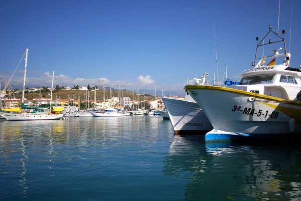 Vista de barcos de pesca y yates amarrados en el puerto con edificios urbanos en la parte trasera, Caleta de Vélez, España . — Foto de Stock