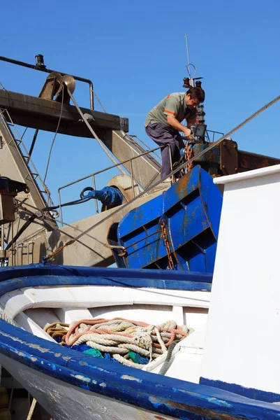 Homme travaillant sur un chalutier amarré dans le port, Caleta de Velez, Espagne . — Photo