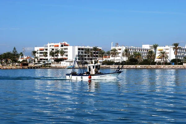 Barco de pesca tradicional que entra en el puerto con apartamentos en la parte trasera, Caleta de Vélez, España . —  Fotos de Stock