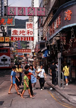 Chinese people crossing a busy shopping street, Aberdeen, Hong Kong. clipart