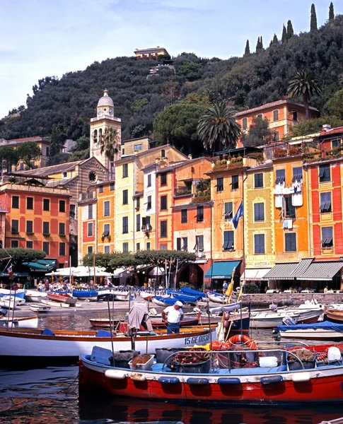 Tradiční rybářské lodě v přístavu s městem dozadu, Portofino, Itálie. — Stock fotografie