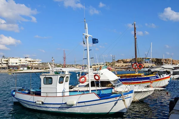Barcos de pesca tradicionais no porto com restaurantes à beira-mar para as traseiras, Hersonissos, Creta . — Fotografia de Stock