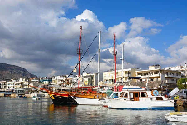 Jachten en boten in de haven met waterkant restaurants aan de achterzijde, Hersonissos, Kreta. — Stockfoto