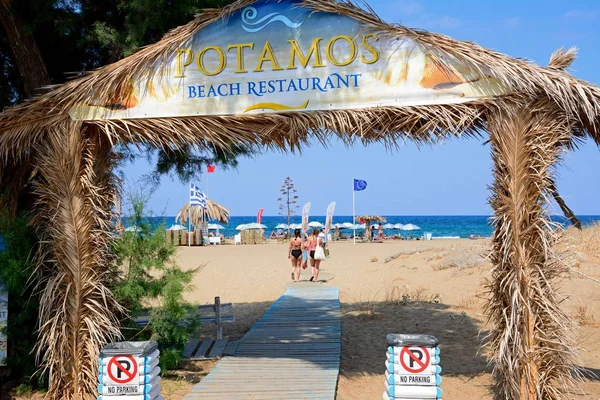 Arco de entrada a la playa de Potamos con turistas disfrutando del entorno, Malia, Creta . — Foto de Stock