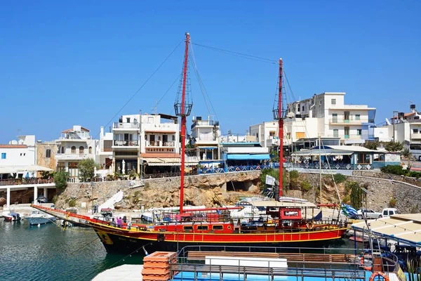 Пиратский корабль Black Rose пришвартовался в гавани с ресторанами на набережной в тылу, Сисси, Крит . — стоковое фото